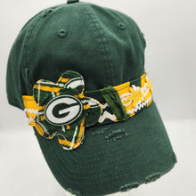 Load image into Gallery viewer, A dark green distressed baseball cap featuring a Green Bay Packers themed fabric band and a large decorative bow with the team's green, yellow, and white colors, displayed on a white mannequin head.