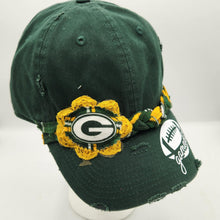 Load image into Gallery viewer, A distressed green bay packers baseball cap with a yellow and green crochet flower accent and a white script logo on the brim, displayed on a white mannequin head against a white background.
