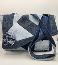 Load image into Gallery viewer, Shop this eco-friendly upcycled denim bag, handcrafted with a patchwork design, adjustable strap, and unique floral detail. Sustainable fashion made from repurposed jeans.