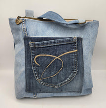 Load image into Gallery viewer, Shop this one-of-a-kind handmade upcycled denim tote bag featuring a floral appliqué design, adjustable strap, and zippered closure. Sustainable, stylish, and perfect for everyday use.