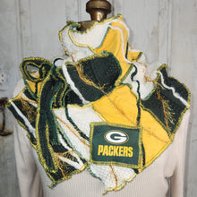 Load image into Gallery viewer, A handmade Green Bay Packers themed scarf displayed on a cream-colored mannequin torso. The scarf is made from various patches of yellow, green, and white knit fabric with frayed edges, featuring a prominent 'PACKERS' logo patch on the front.