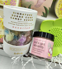 Load image into Gallery viewer, Two beauty products: a container of &#39;Signature Sugar Cube Candy Scrub&#39; and a jar of &#39;Let&#39;s Get Steamy&#39; shower steamers on a white surface.
