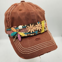 Load image into Gallery viewer, Handmade distressed brown baseball cap featuring embroidered floral appliqués, colorful boho trim, lace accents, and decorative leaf charm
