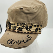 Load image into Gallery viewer, A distressed khaki military-style cap with a decorative patterned band and black embroidery on the brim, displayed on a white mannequin head against a white background.
