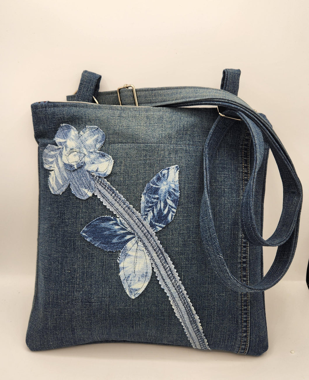 upcycled denim bag, handmade crossbody purse, floral appliqué shoulder bag, eco friendly tote, recycled jeans bag, boho denim handbag, sustainable fashion accessory, handmade shoulder bag, unique denim purse, artisan fabric bag, repurposed fabric crossbody